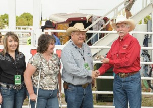 Dr. Schufeldt is presented with a commemorative buckle by Jack Morris, Buffalo Bill Rodeo chairman, at the 2014 Buffalo Bill Rodeo in North Platte, while his wife Jeannie and daughter Krista look on. Photo by George Hipple.