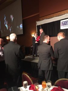Dr. Caroline Winchester gets a standing ovation from her peers, school board members and other public education interests as she is presented with a plaque commemorating her "2016 Nebraska Superintendent of the Year' honor.